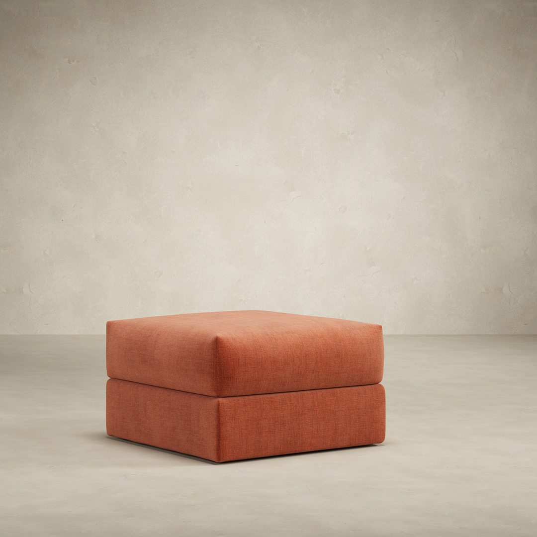 Rust colored ottoman on a plain background